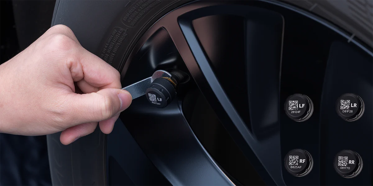 ręka dokręcająca kluczem zawór przy oponie